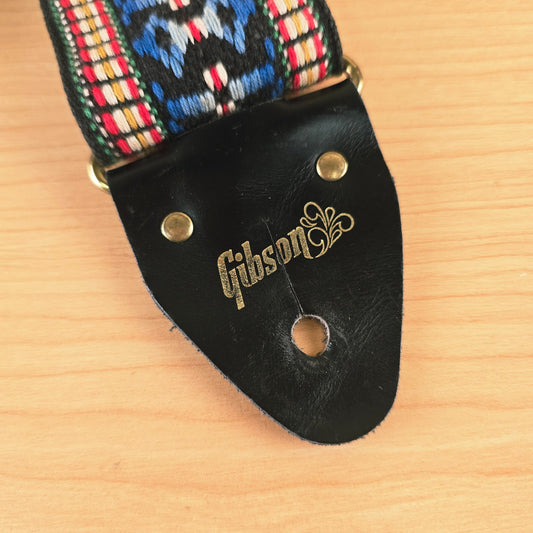 Close-up of the black leather end tab showing the gold foil Gibson logo