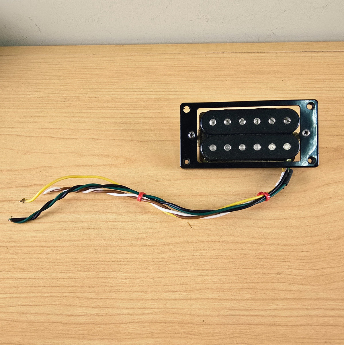 Direct top view of the Schaller humbucker pickup in its black mounting ring
