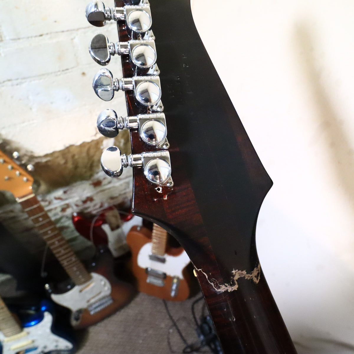 Close-up view of the headstock crack repair and finish touch-up near the neck transition.
