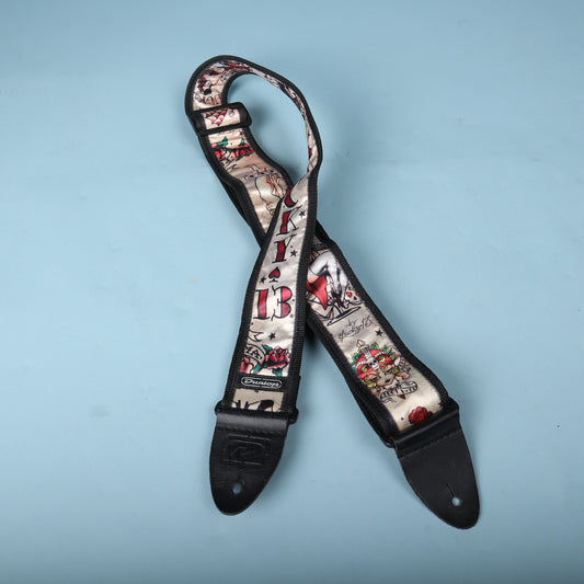 Crossed front view of the Dunlop Lucky 13 Japan Tattoo guitar strap