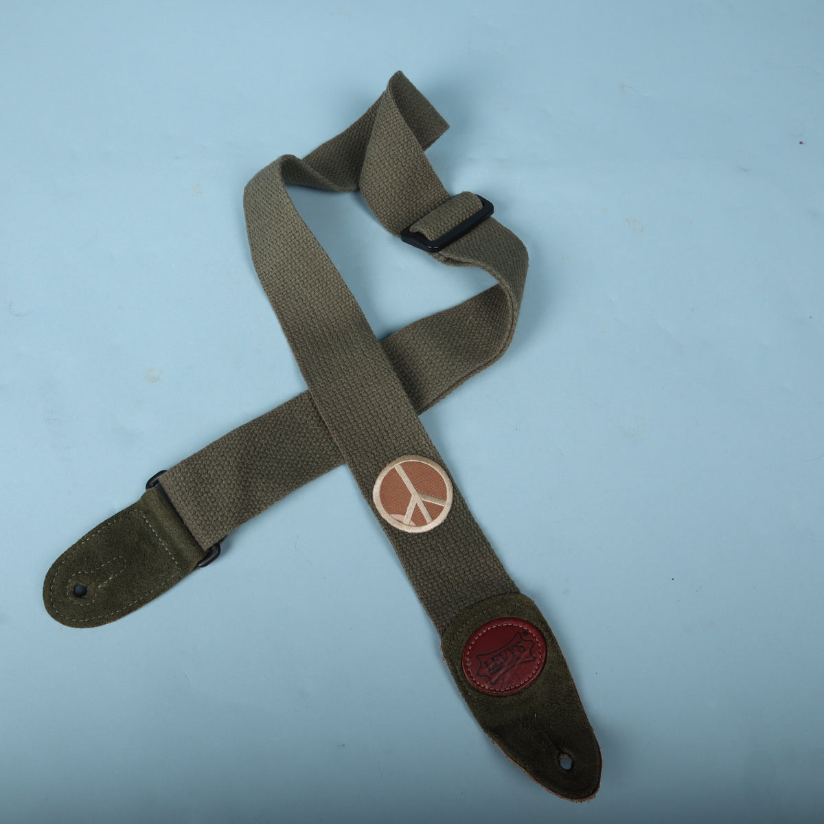 Levy's olive green cotton guitar strap displayed against a light blue backdrop