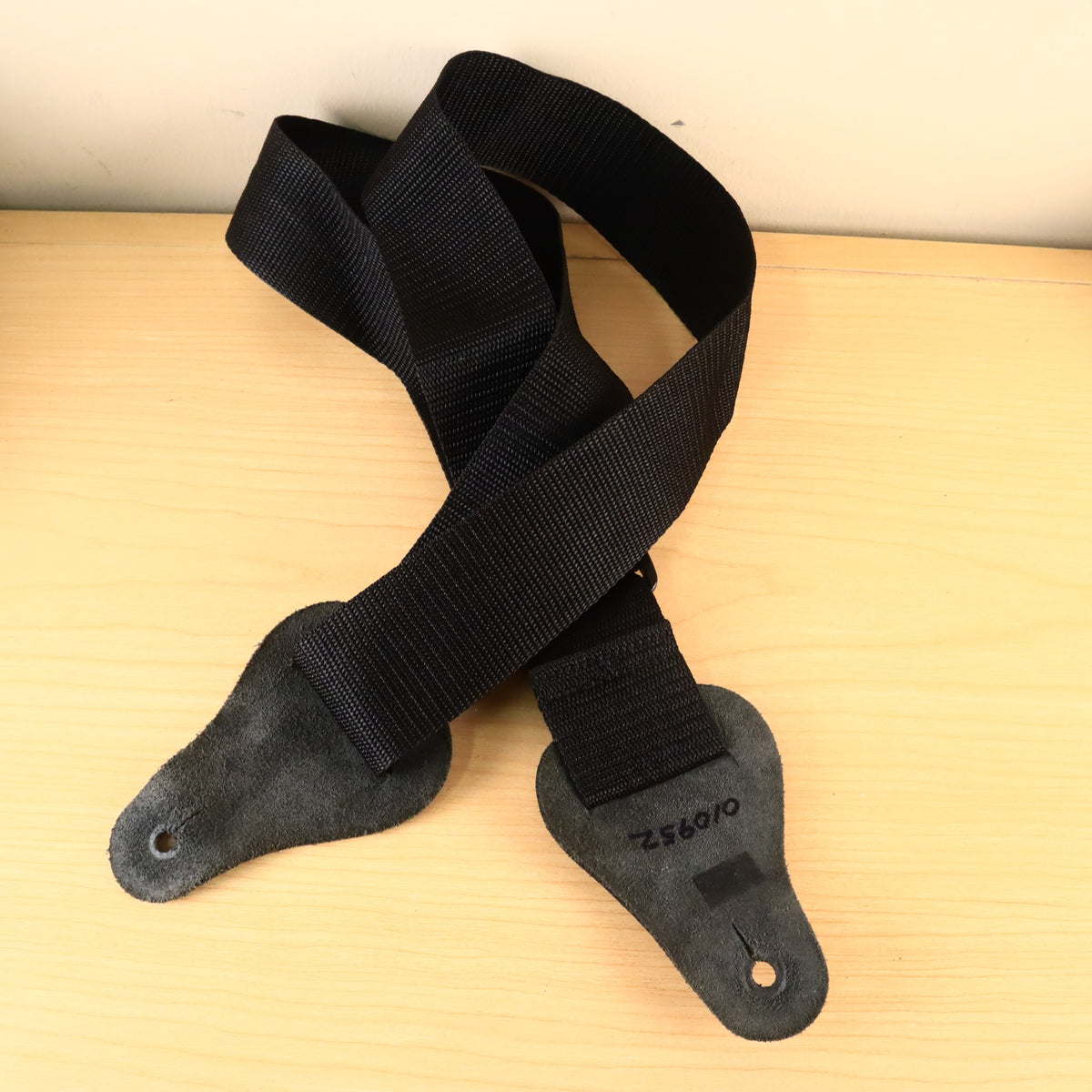 Back view of black Fort Bryan strap showing leather tab undersides and handwritten number.