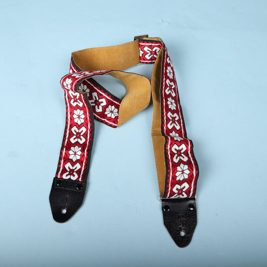 Folded view of the 1960s bohemian woven guitar strap displaying the jacquard pattern and leather attachment ends