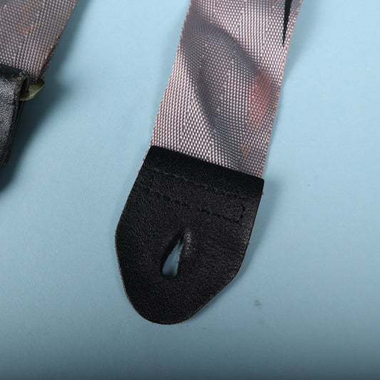 Close-up of the black leather strap end showing stitching and button hole slit.