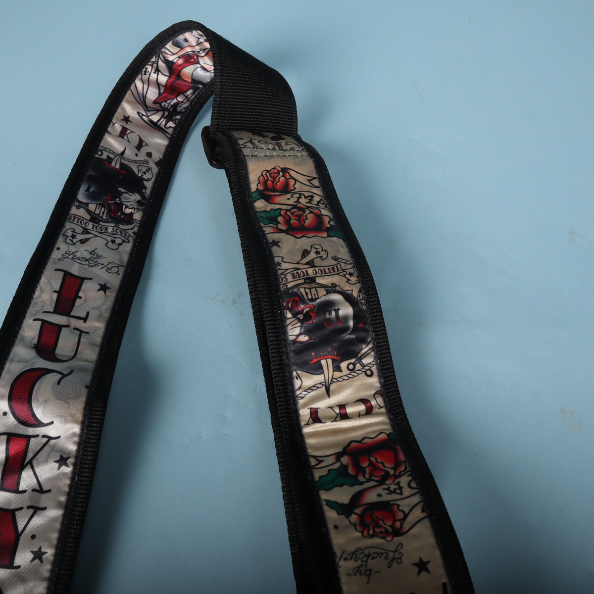 Detail of the rose, dagger, and banner graphics along the upper section of the strap