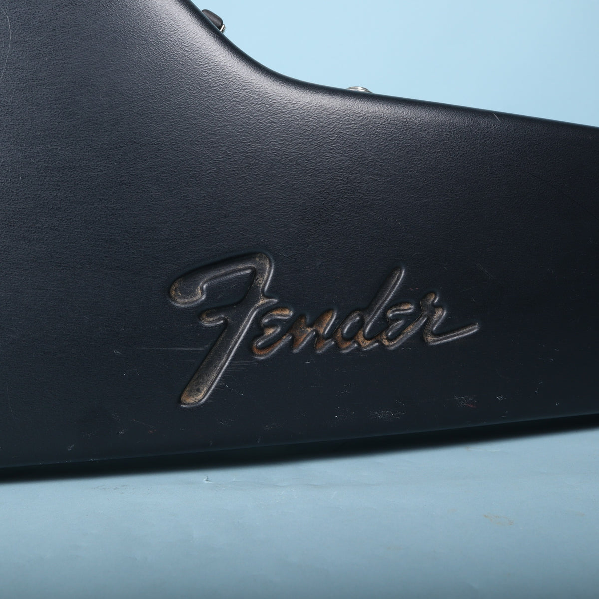 Close-up of embossed Fender script logo on black molded exterior