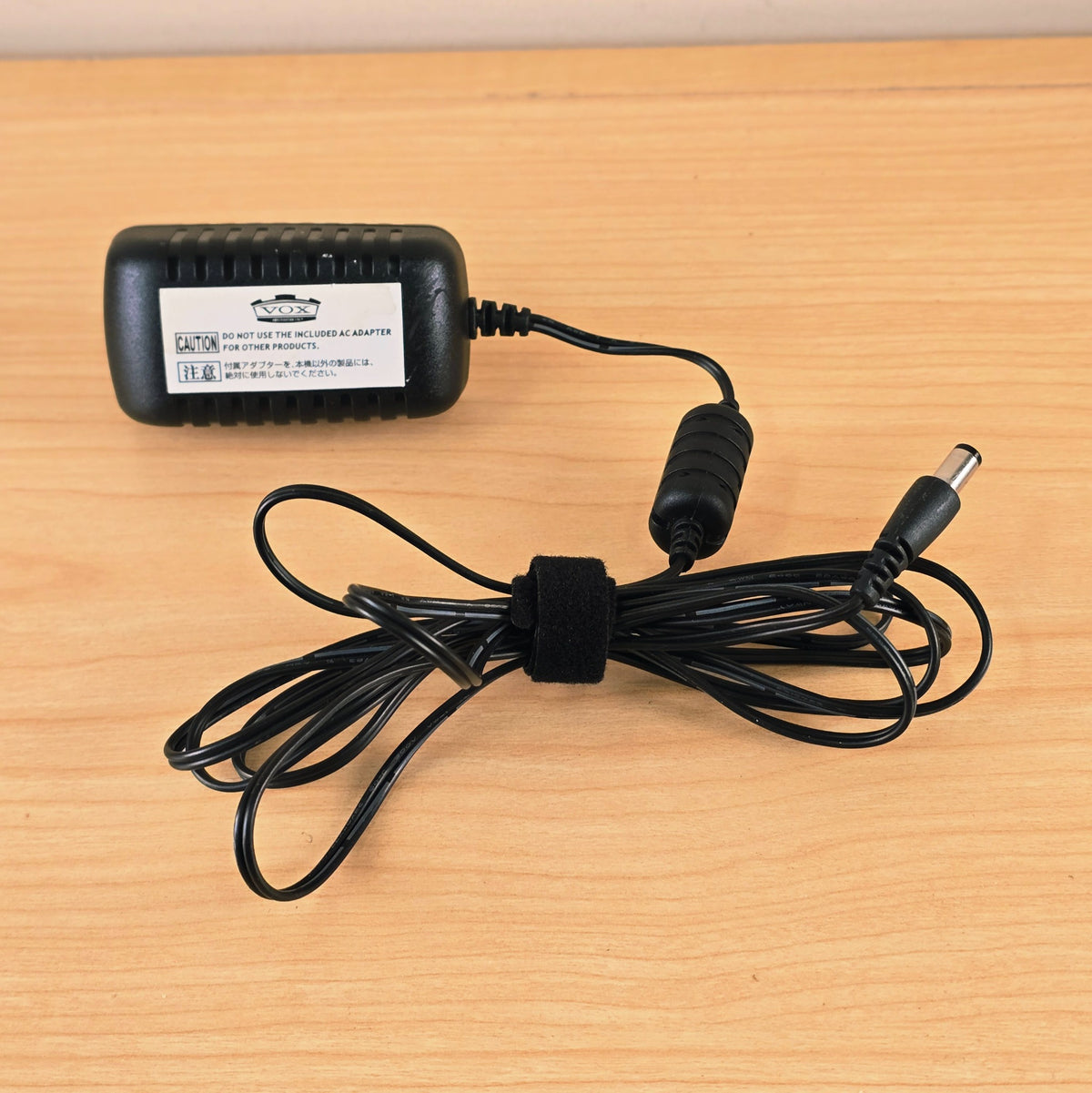 Vox KA253V power supply body and gathered cable on a light wood surface