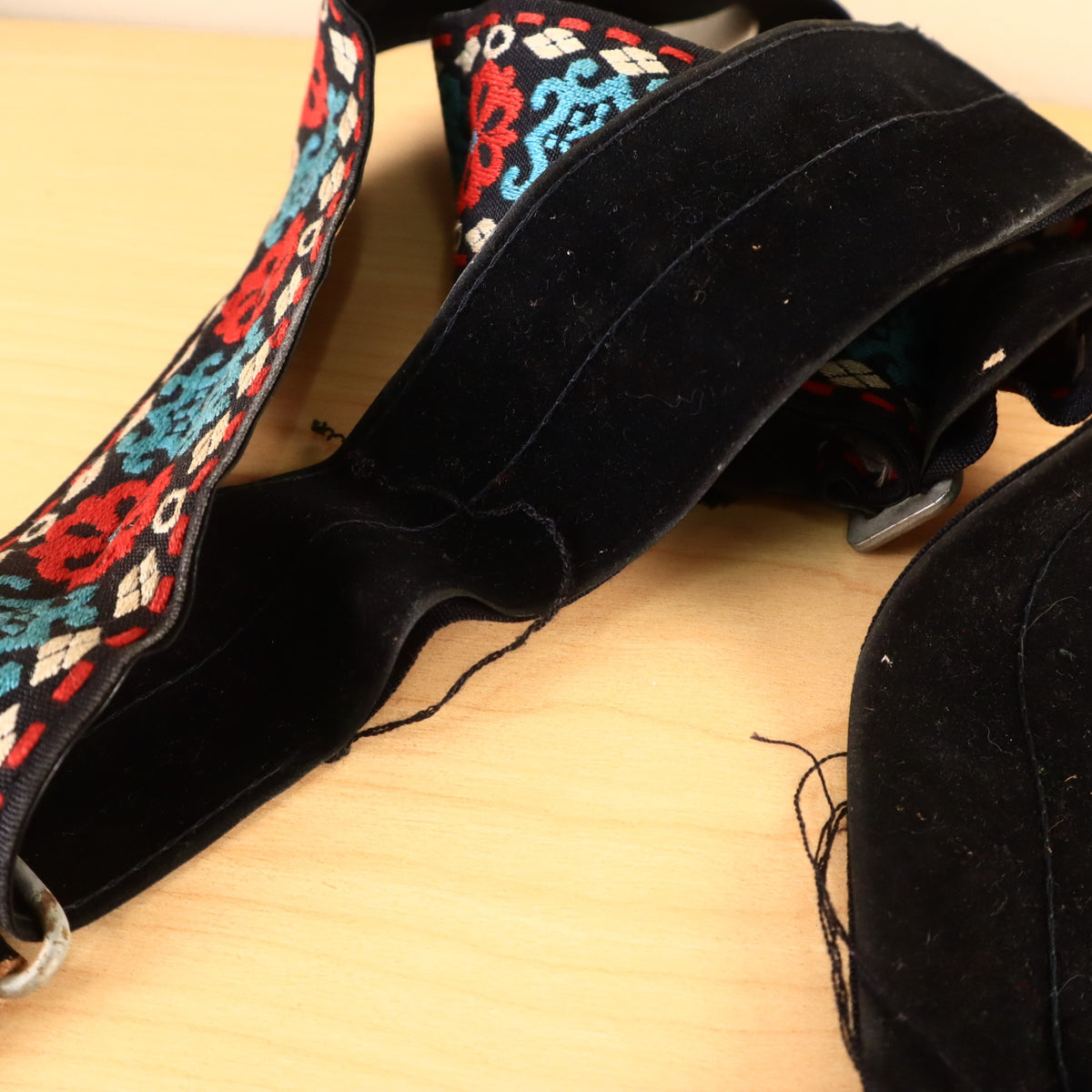 Woven jacquard strap pattern with metal buckle and loose threads.