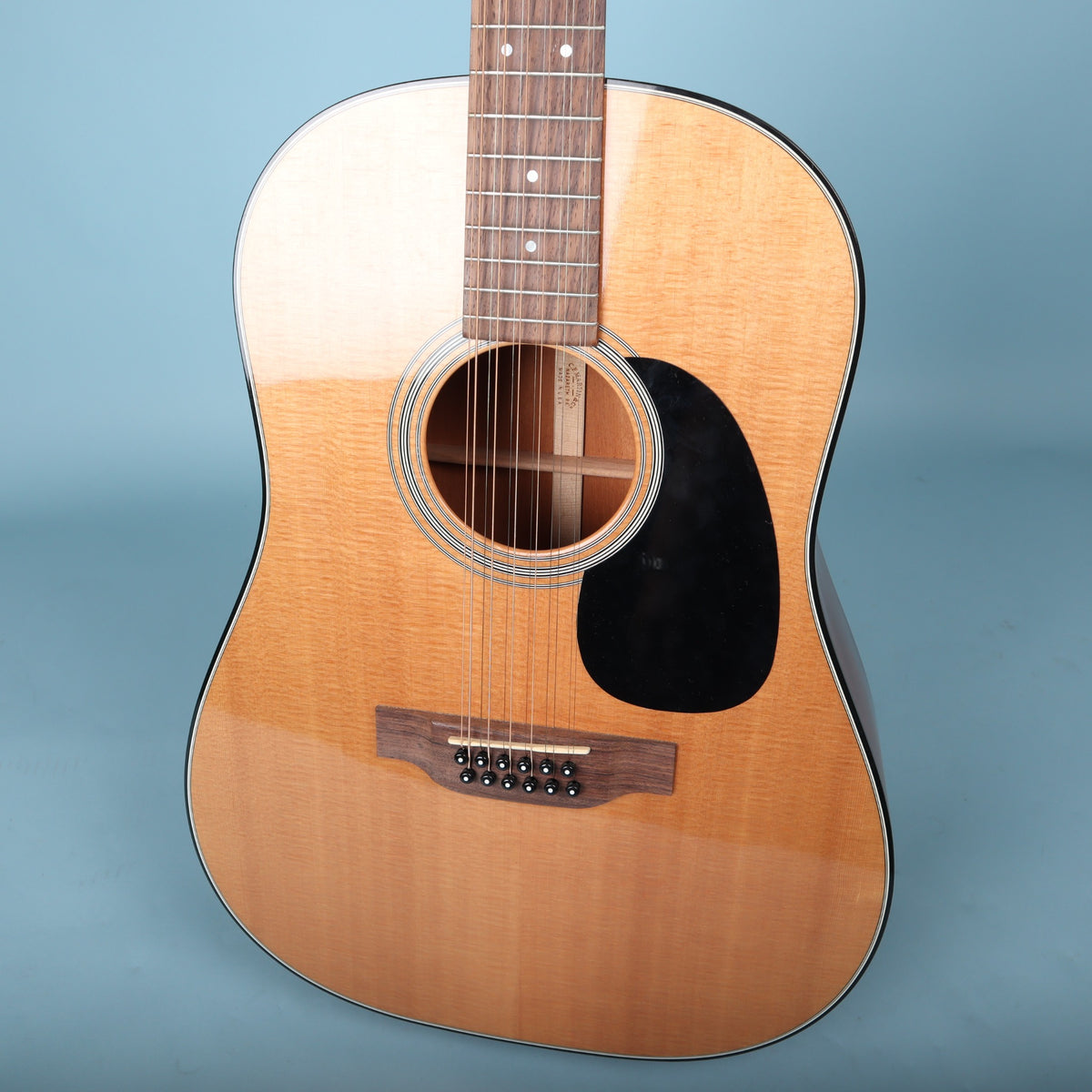 Close front view of Sitka spruce top soundhole and rosewood bridge