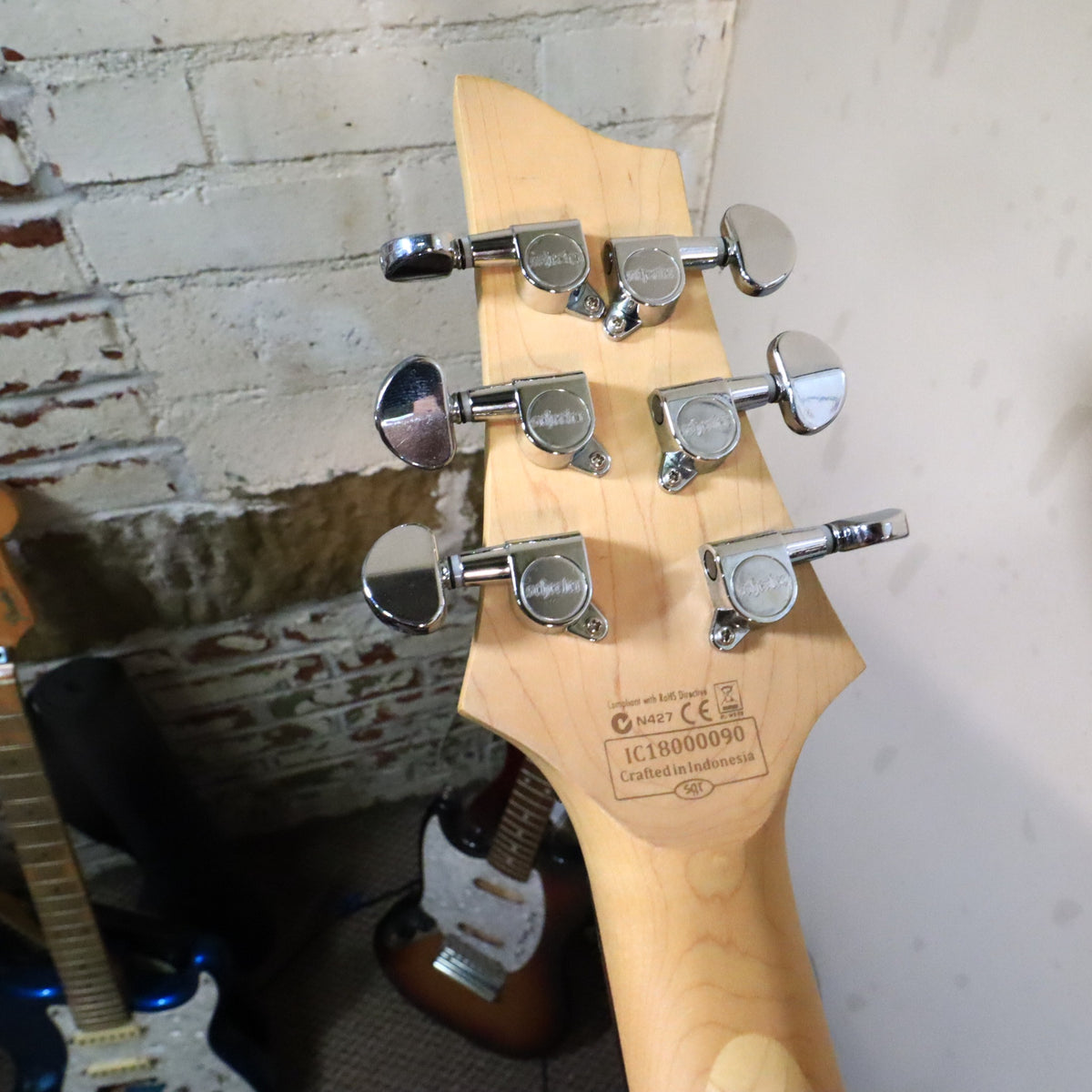 Close-up of the back of the headstock showing serial number IC18000090 and Crafted in Indonesia stamp..120 chars max achieved