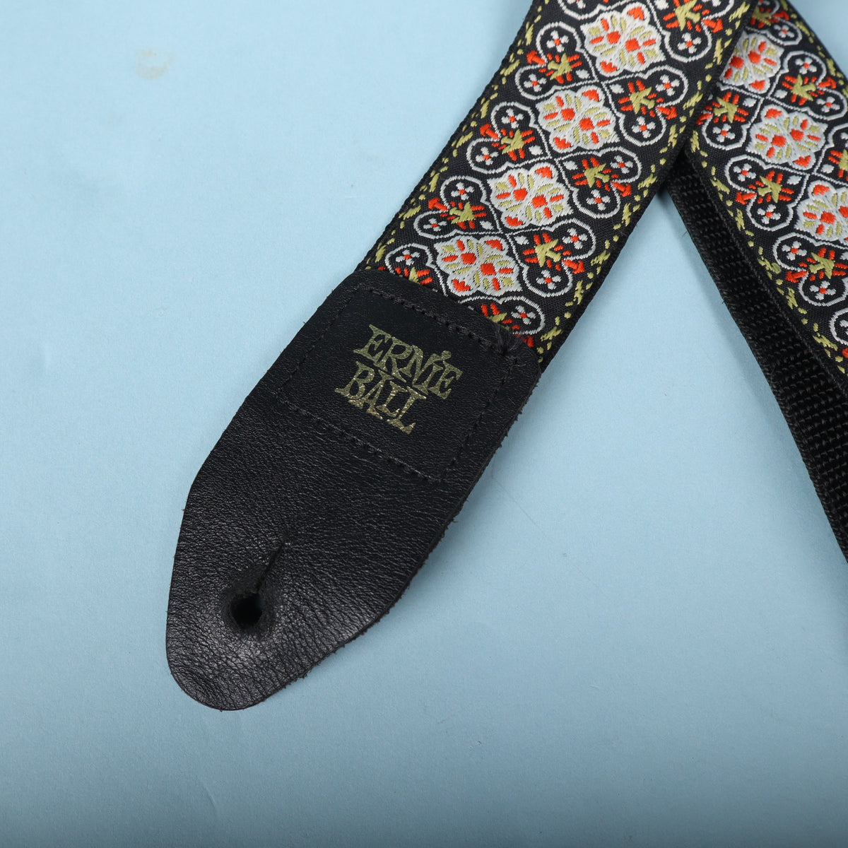 Detailed view of the gold Ernie Ball branded leather tab and stitching
