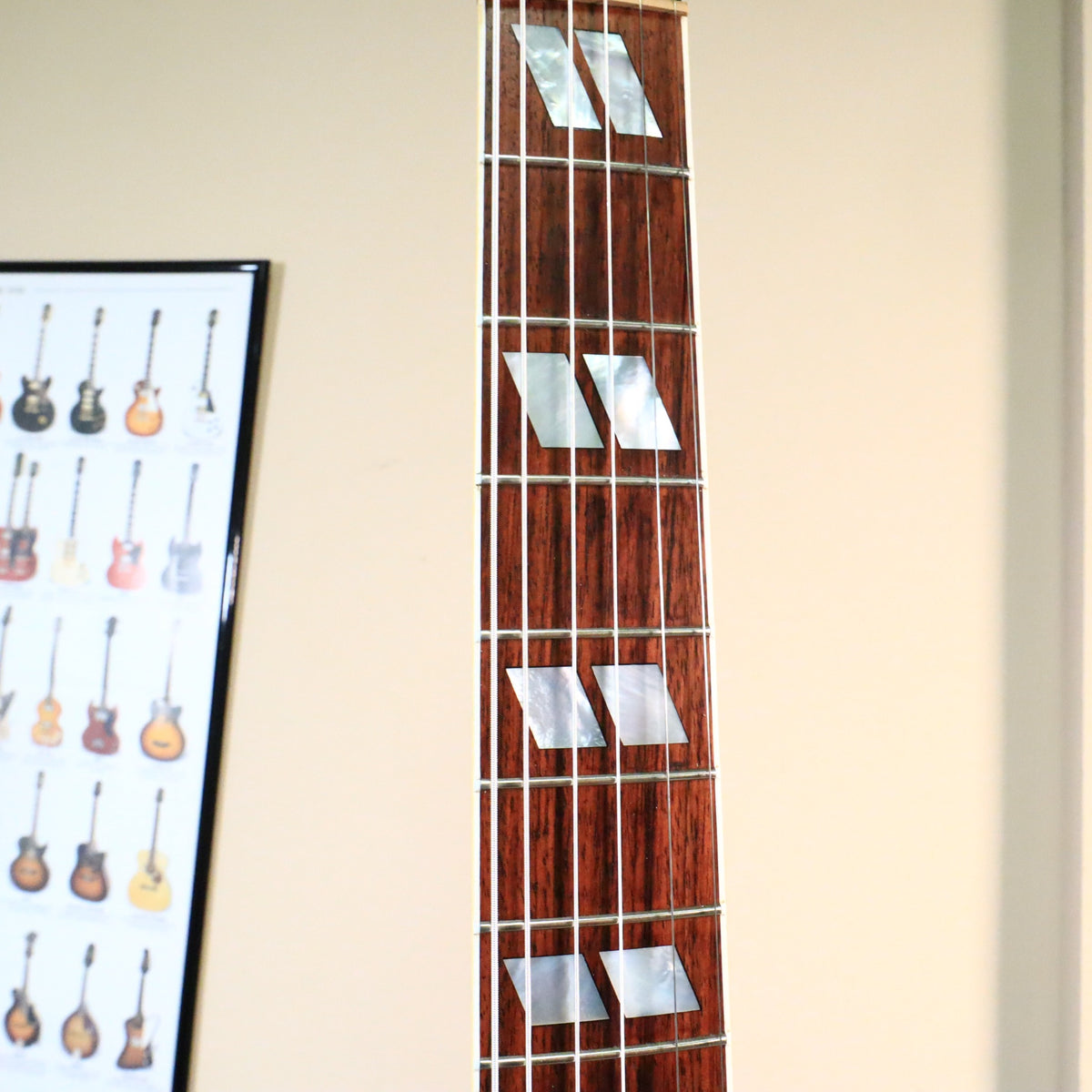 Close-up of the rosewood fretboard showing mother-of-pearl split parallelogram inlays.