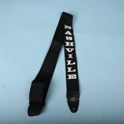 Overhead shot of the LM Products Nashville guitar strap laid out against a blue backdrop