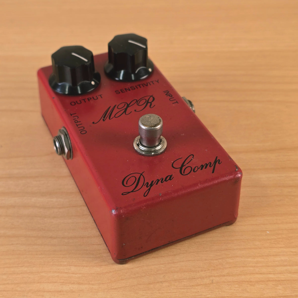 High-angle view showing the faceplate controls and footswitch of the MXR Dyna Comp compressor.