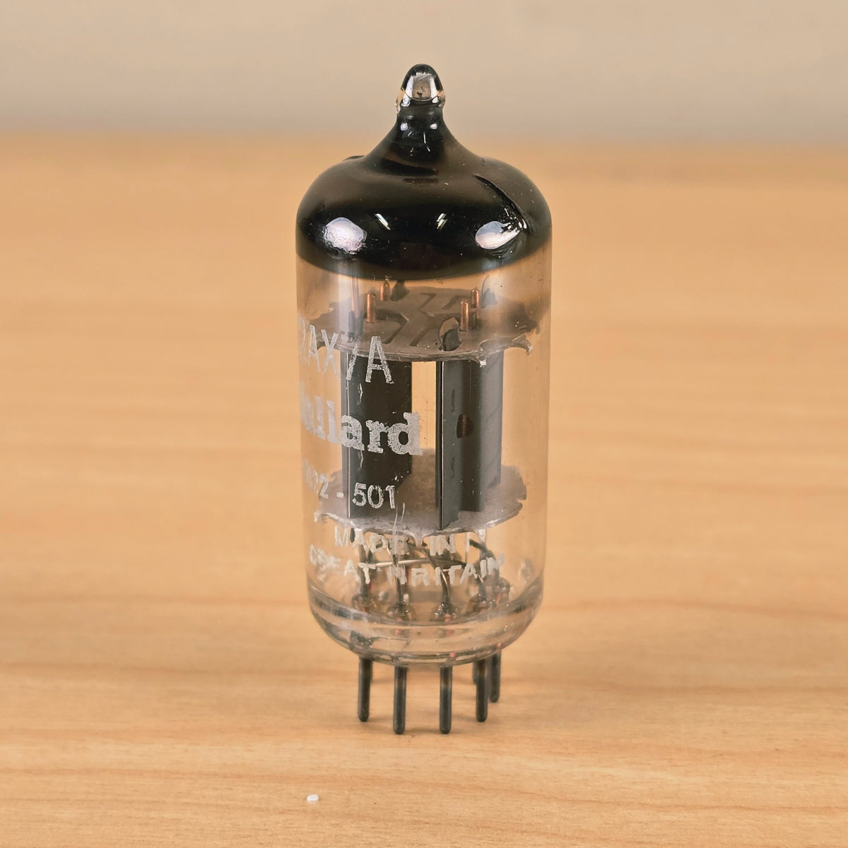 Upright front view of Mullard 12AX7A vacuum tube with Great Britain printing visible.