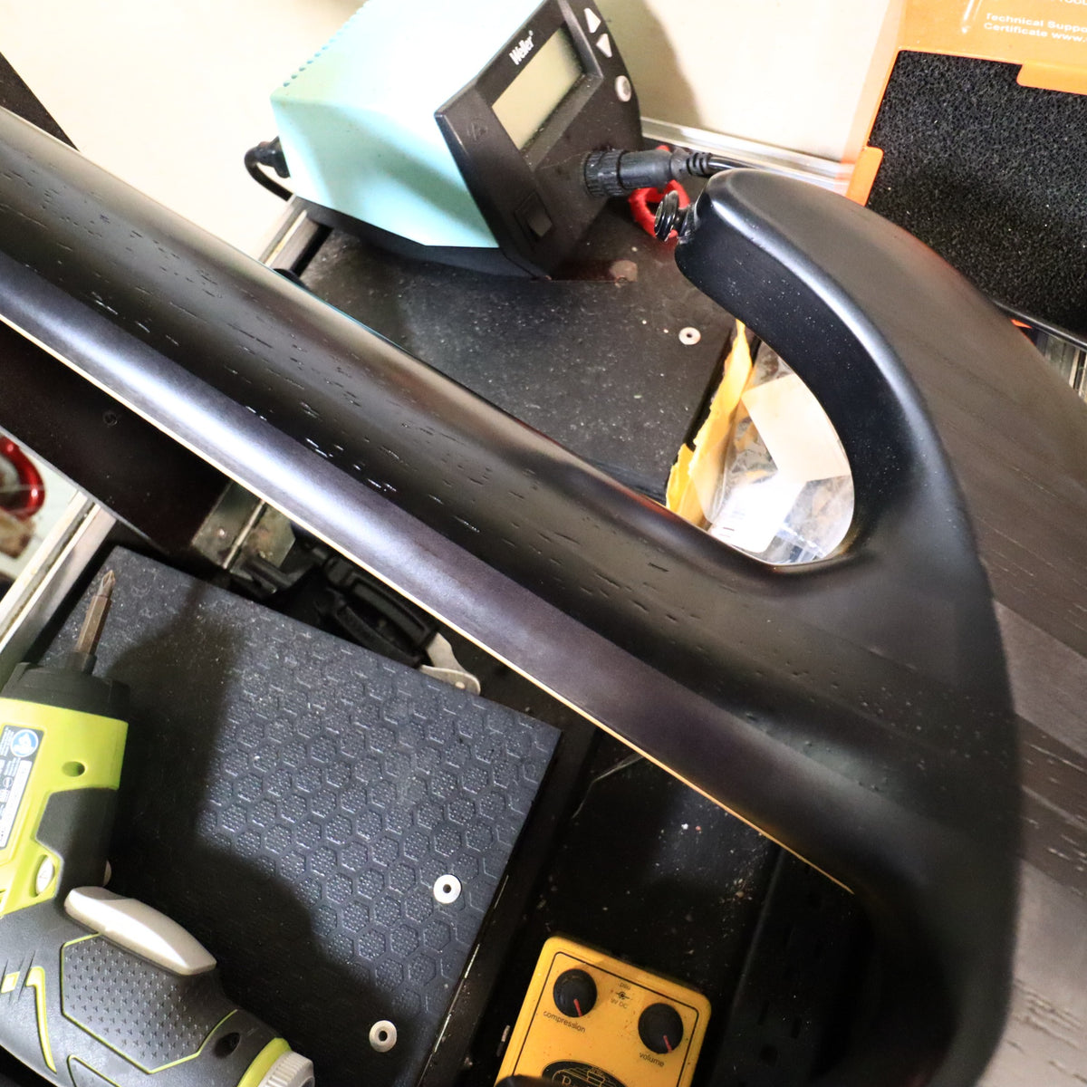 Full back view of the guitar body resting on a padded workbench