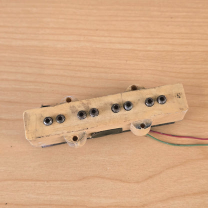 Close-up top view of cream bass pickup cover showing eight pole pieces.