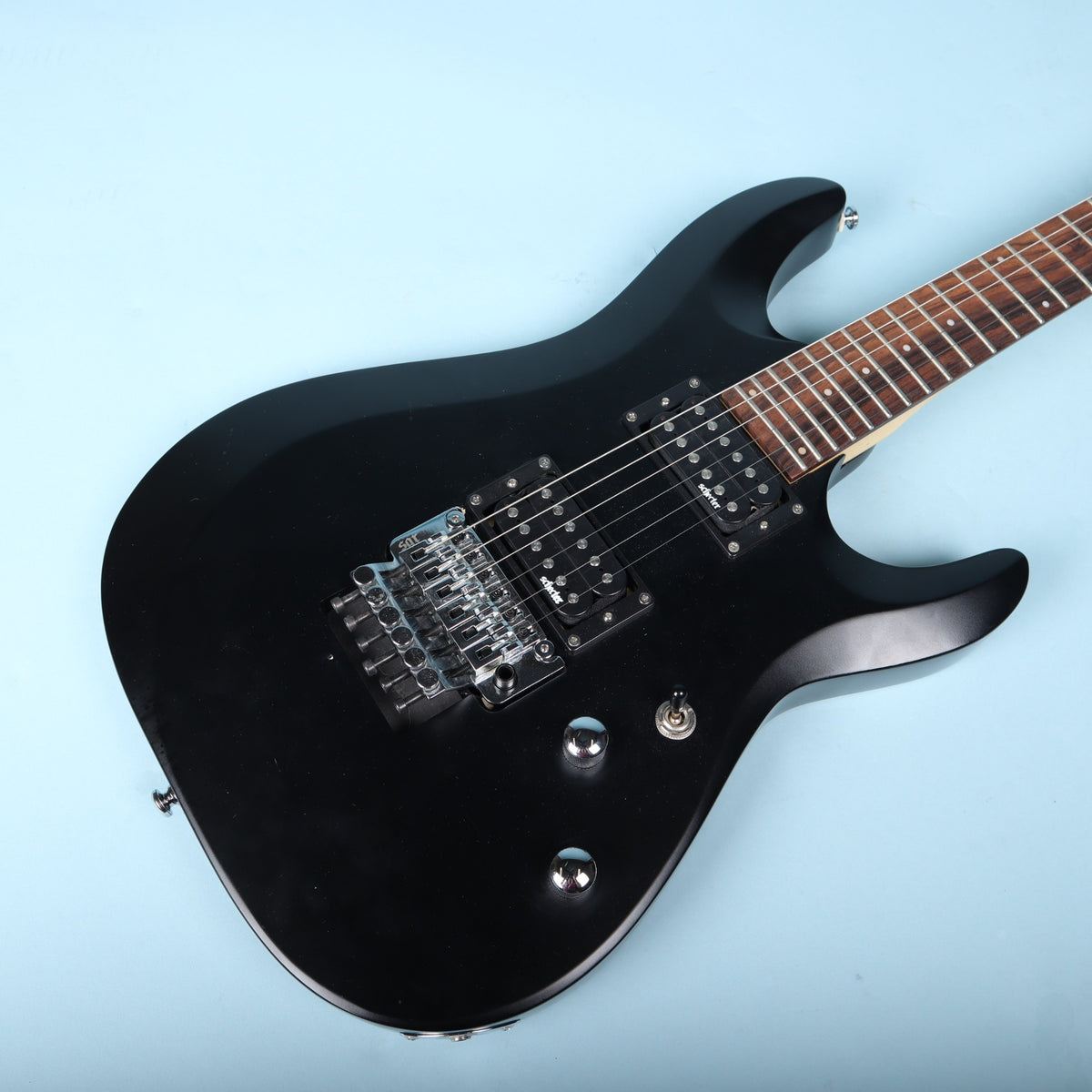 Angled view of the guitar body highlighting the satin black finish and chrome hardware.