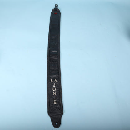Full-length front view of the black leather strap featuring silver-tone letters spelling L.A. JONES.