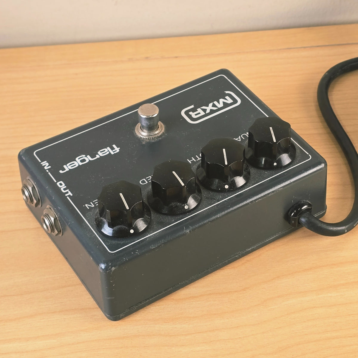 Side view of MXR Flanger pedal showing attached power cable strain relief.