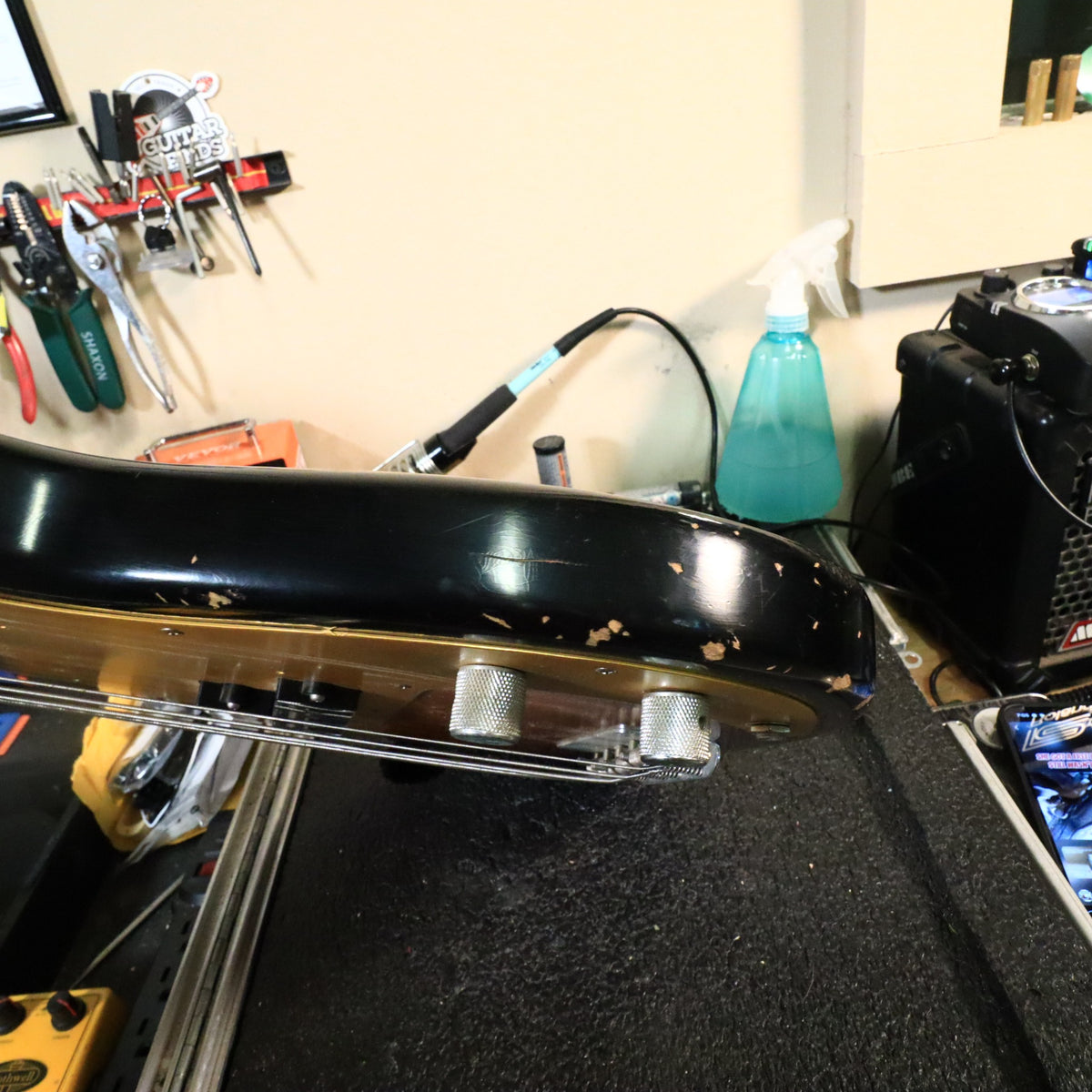 Edge profile of the lower body bout showing distress marks on the workbench.
