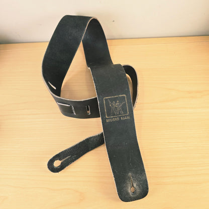 Front view of looped vintage Music Man black leather strap displaying adjustment tail