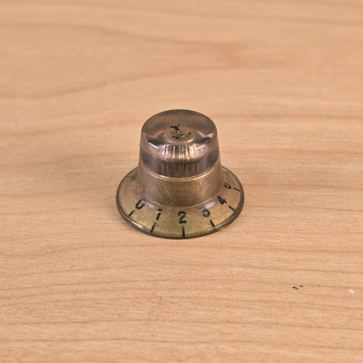 Close-up profile of gold top hat guitar control knob