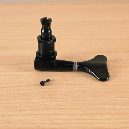 Three black Gotoh Modulus bass tuning pegs displayed together on wood