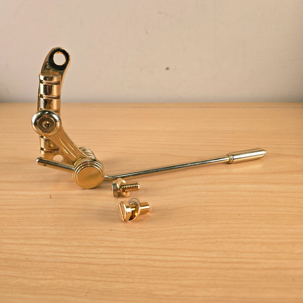 Full perspective view of the gold Duesenberg Les Trem II with extended tremolo arm and mounting bolts