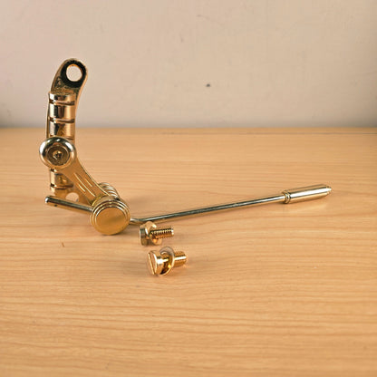 Full perspective view of the gold Duesenberg Les Trem II with extended tremolo arm and mounting bolts
