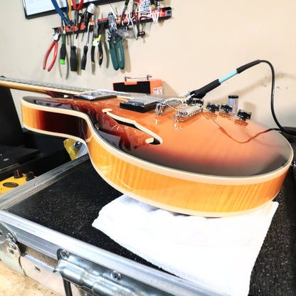 Bass-side rim and binding profile of the guitar on the workbench.