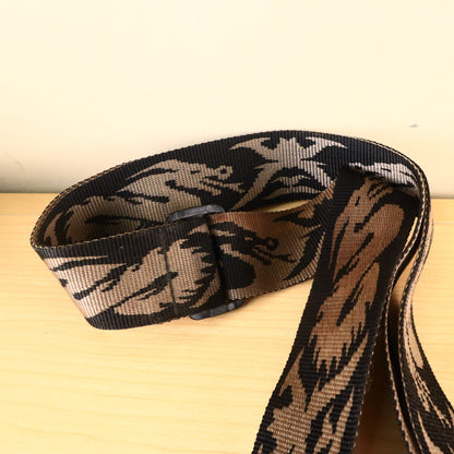 Close-up of the black plastic adjustment buckle and woven brown and black pattern on the strap.