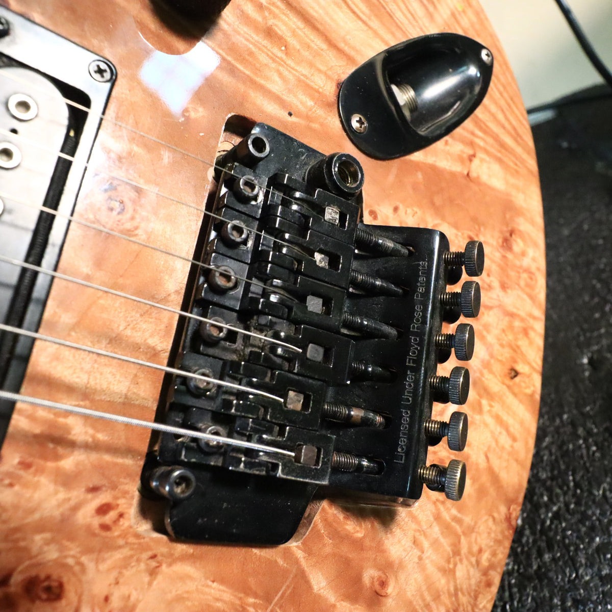 Close-up of black licensed Floyd Rose locking tremolo bridge.