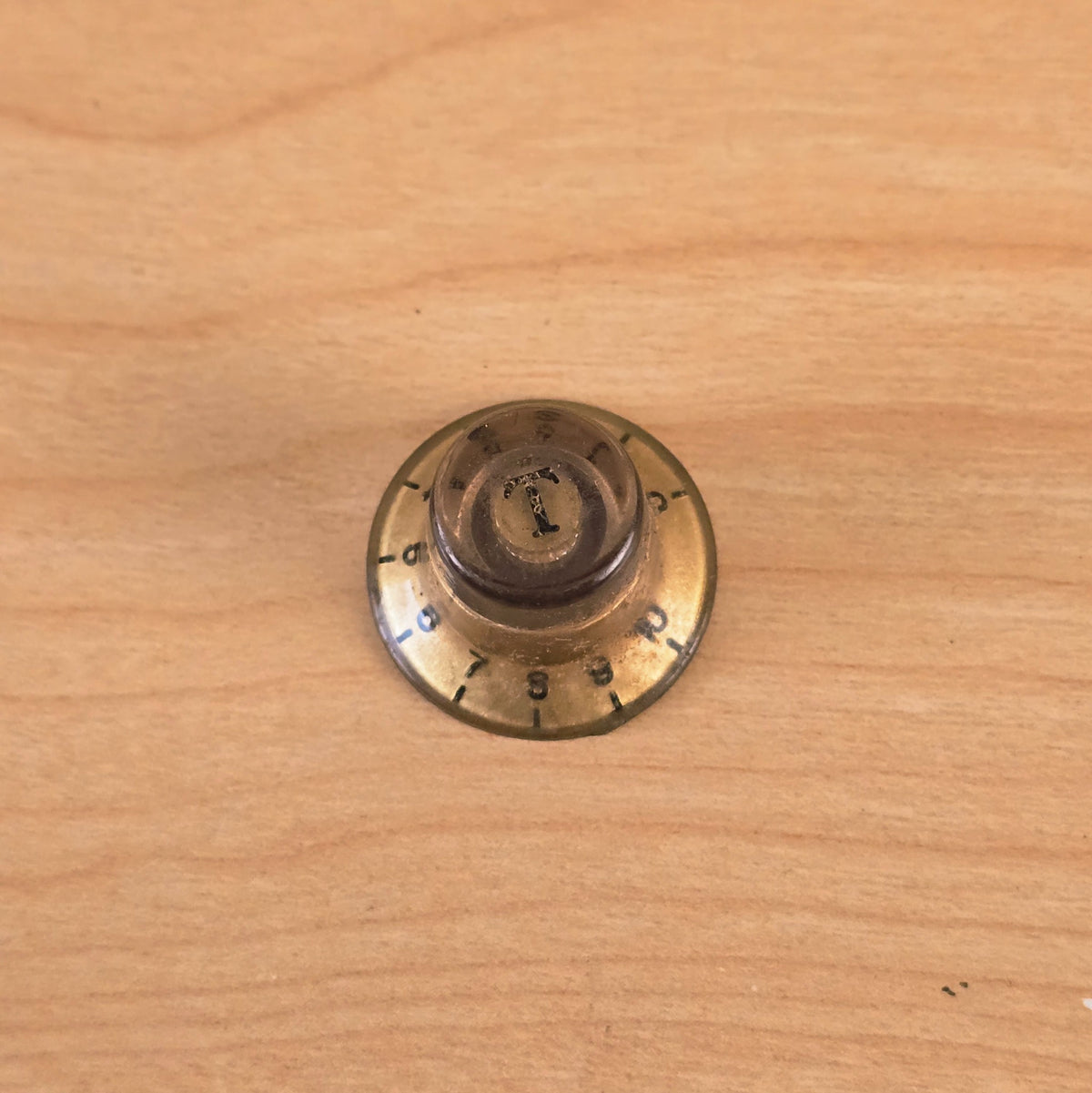 Overhead angle of gold top hat guitar control knob