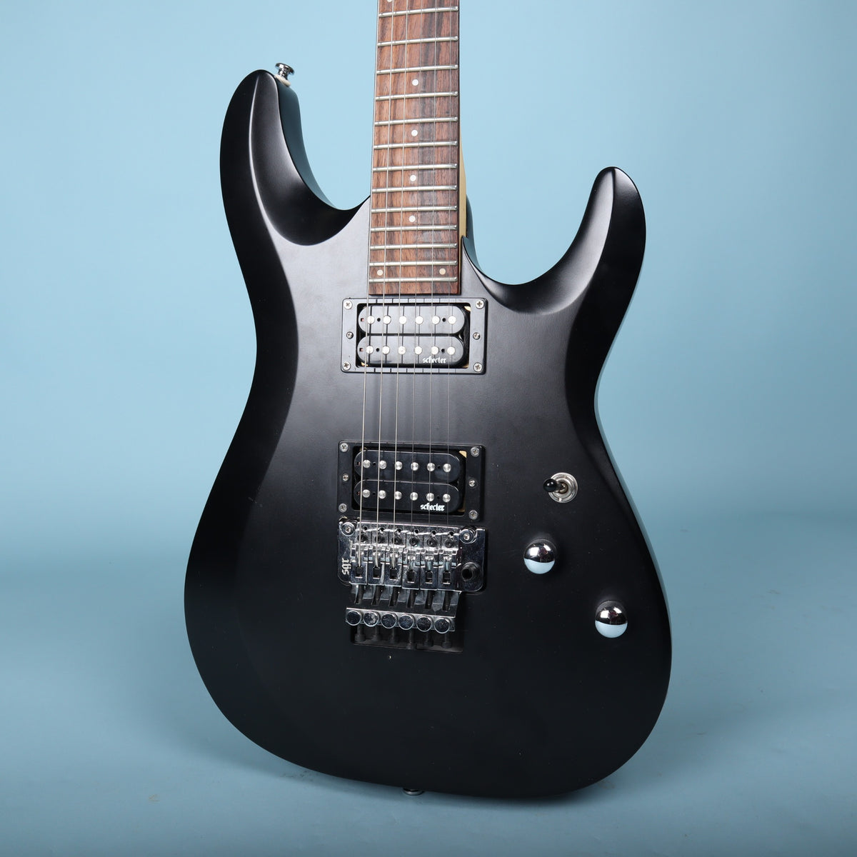 Front view of the Schecter C-6 Deluxe FR body in satin black showing pickups and Floyd Rose bridge.