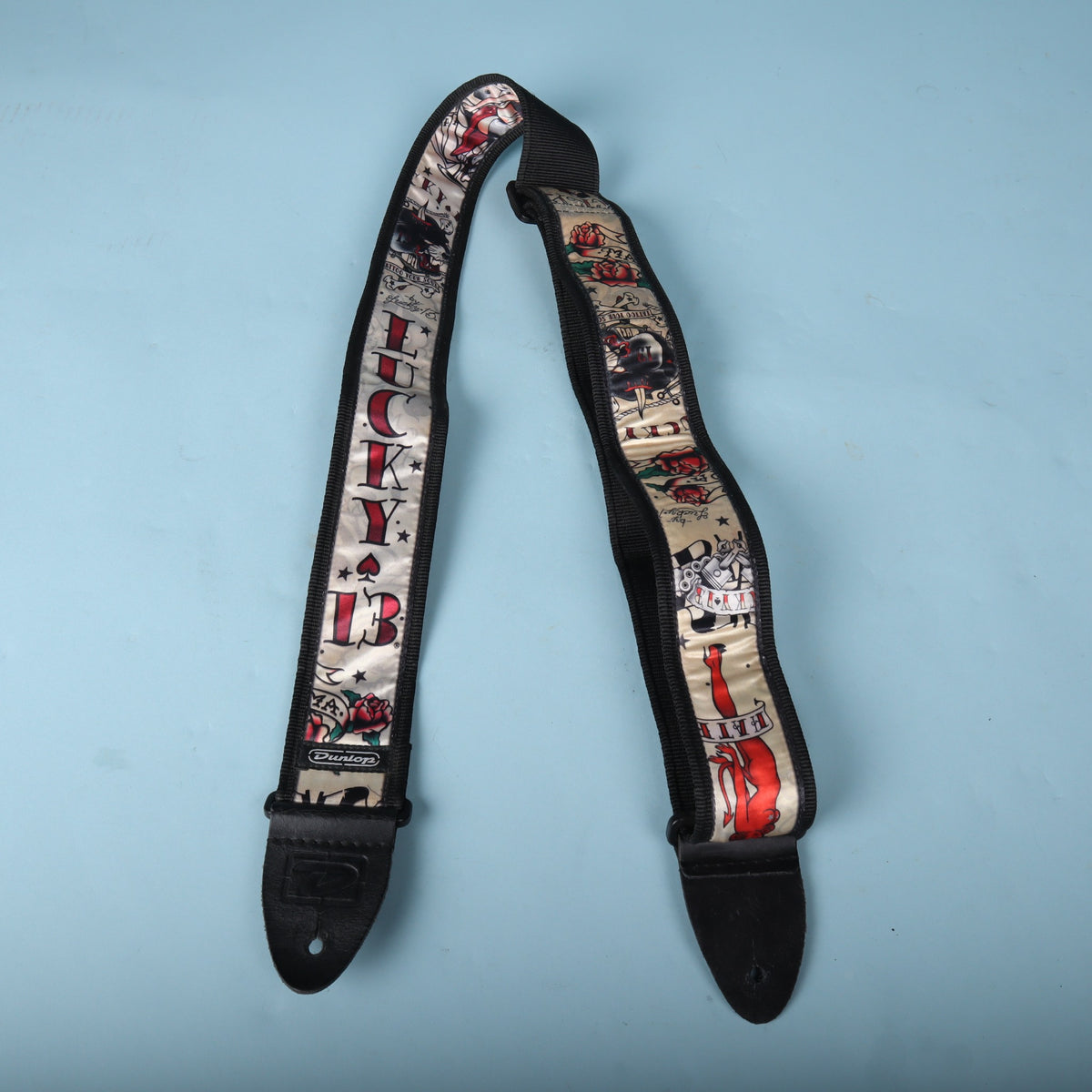 Front-facing view of the complete Dunlop Lucky 13 guitar strap
