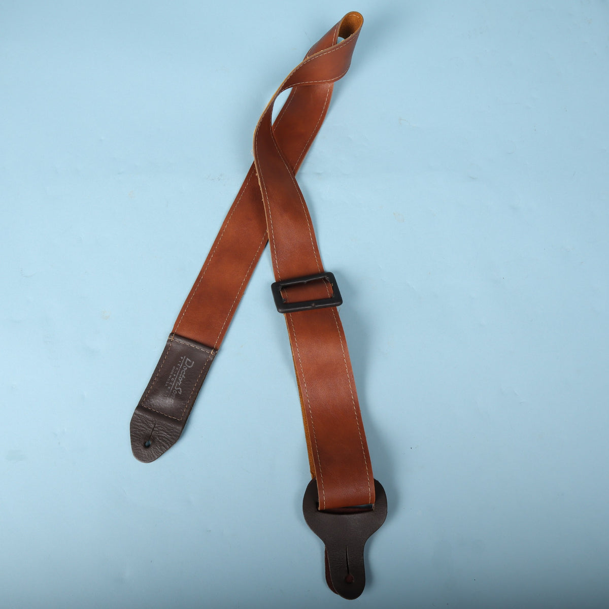 Full view of the Doctor Song Pick-Pocket leather guitar strap showing the adjustment buckle and leather ends.