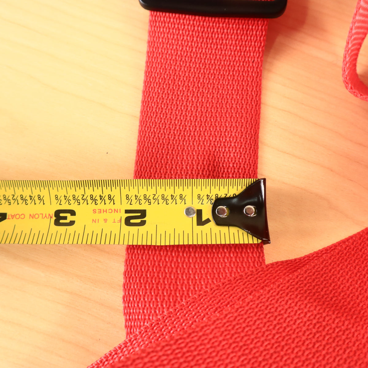 Tape measure across the red strap indicating 2 inches in width.