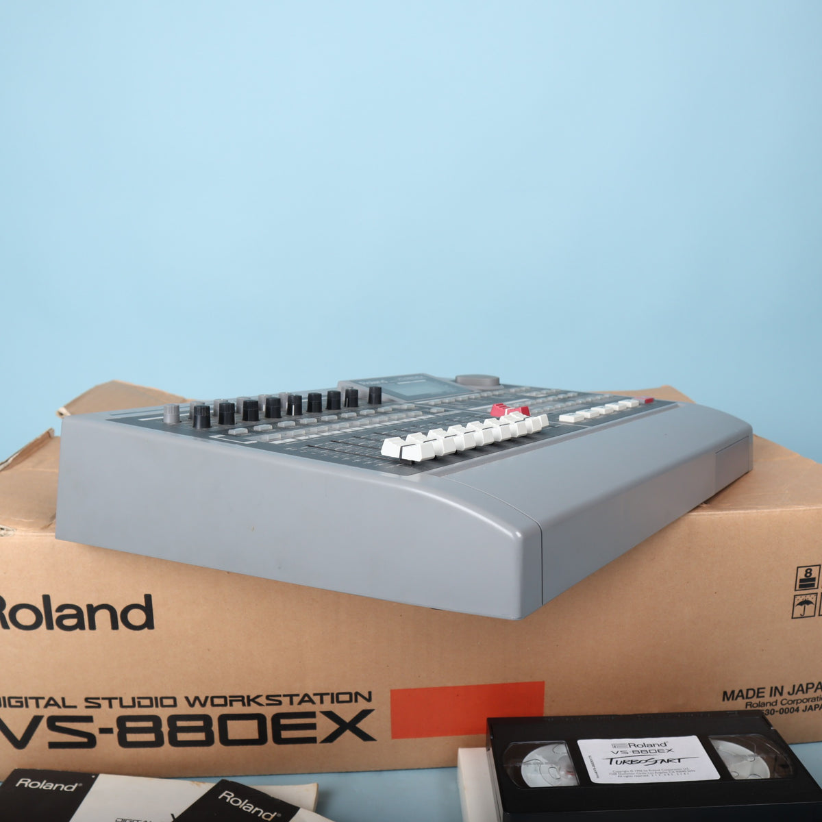Side angle view showing faders, transport buttons, and jog wheel on Roland VS-880EX workstation.