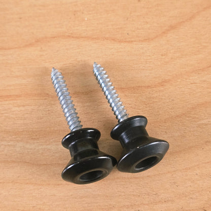 Pair of black Dunlop Straplok strap buttons viewed along the threaded mounting screws
