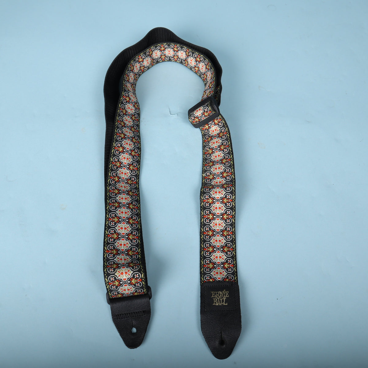 Full view of the Ernie Ball jacquard guitar strap showing both leather end tabs
