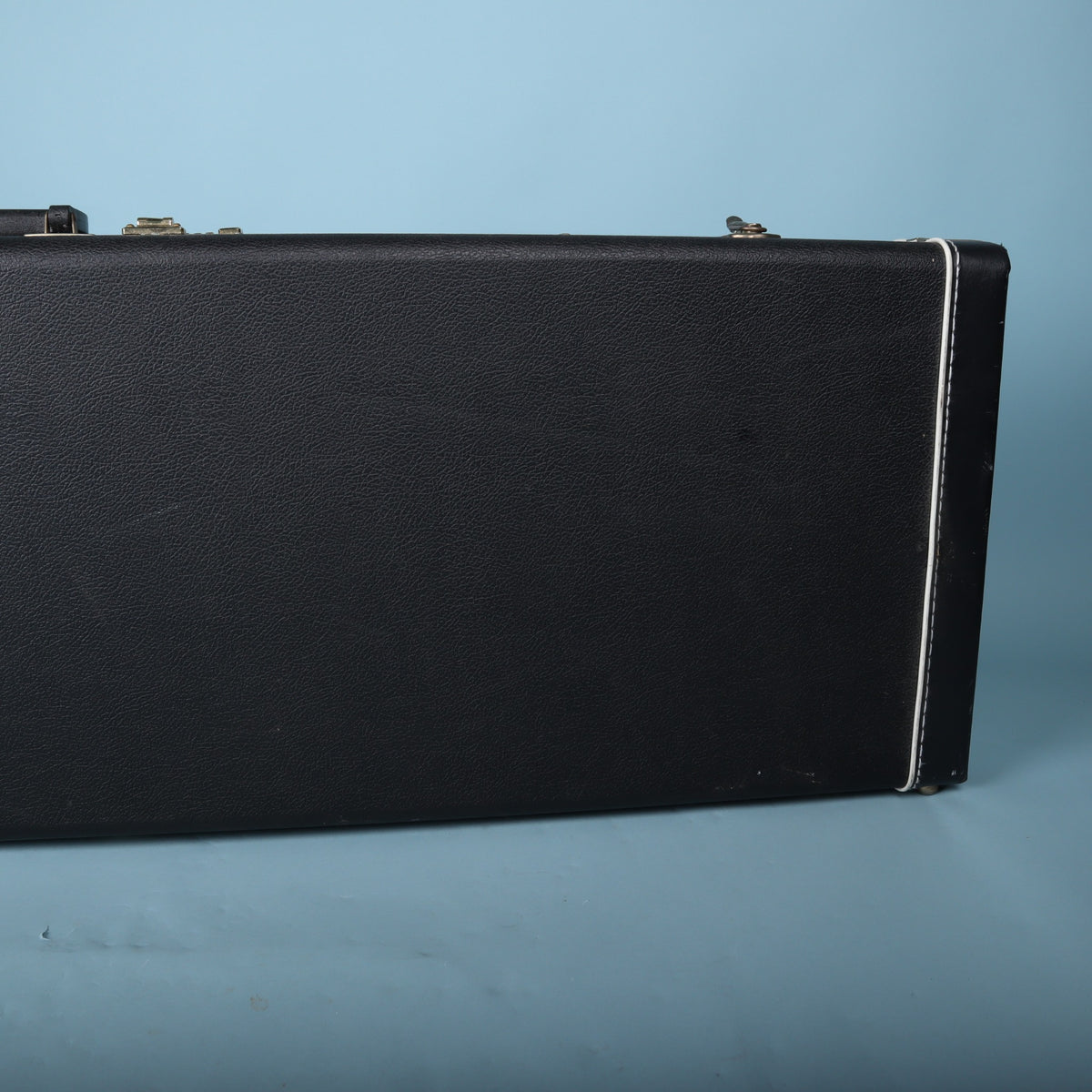 Tobias hardshell bass guitar case side profile showing black exterior and white piping