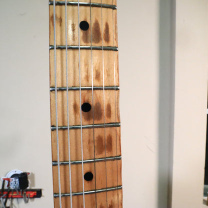 Close-up of maple fretboard showing authentic playing wear between frets