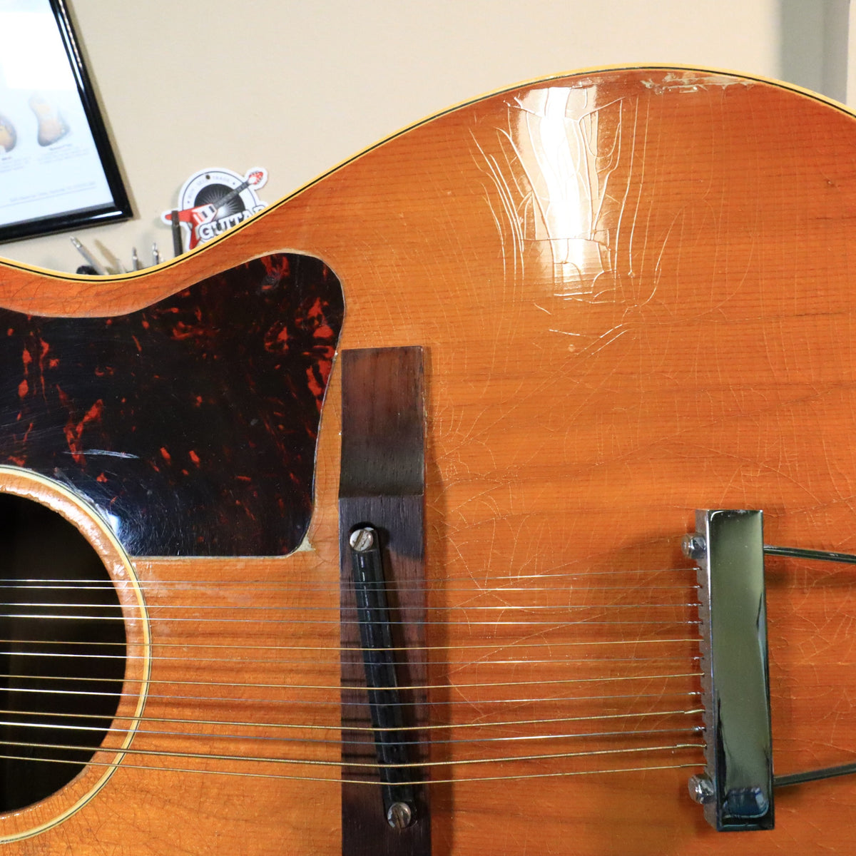 Close-up of the adjustable rosewood bridge and pickguard on a Gibson B-25-12.