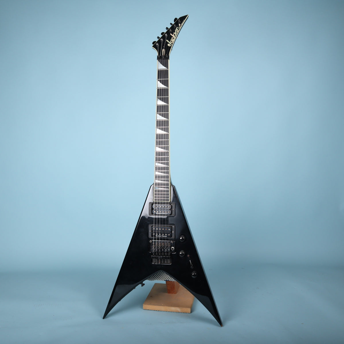 Full front view of the black Jackson USA King V KV2 electric guitar on a stand