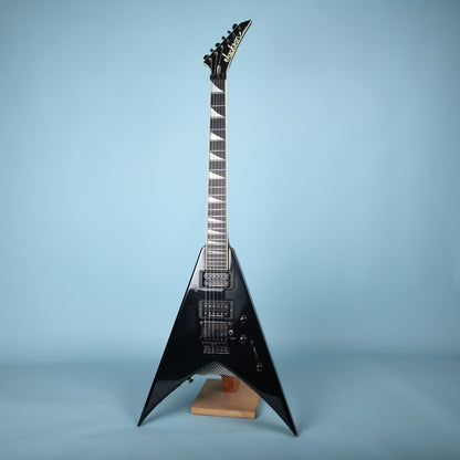 Full front view of the black Jackson USA King V KV2 electric guitar on a stand