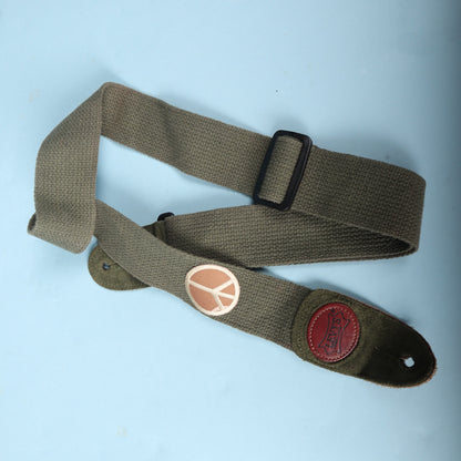 Folded Levy's cotton guitar strap showing the black adjustment slider and peace sign
