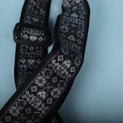 Close-up of the black plastic tri-glide adjustment buckle on the woven strap.