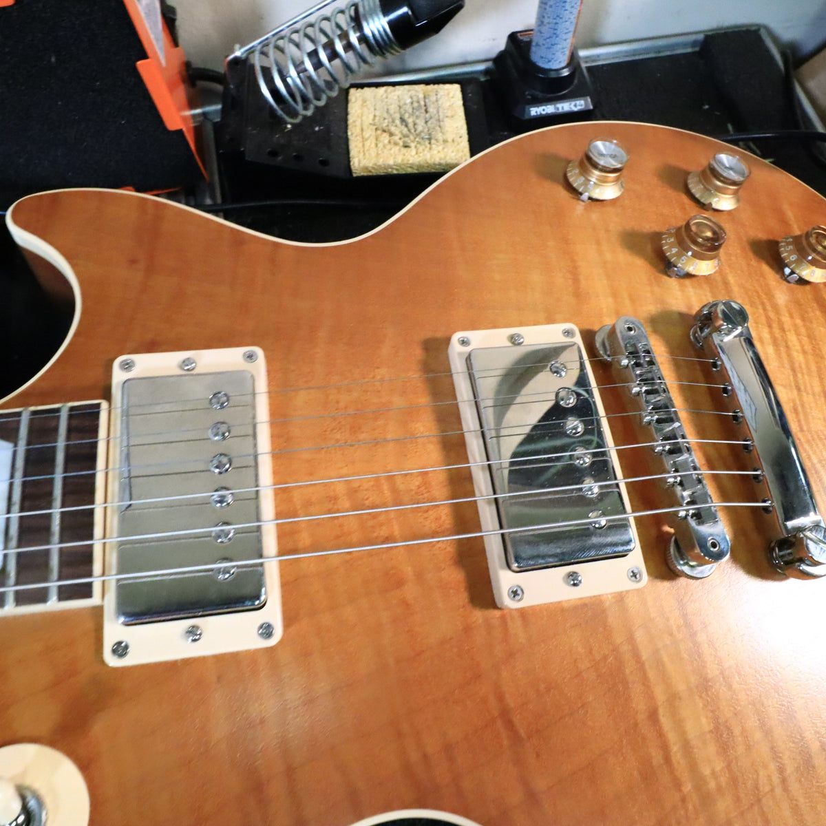 Close-up of covered humbucker pickups and bridge assembly