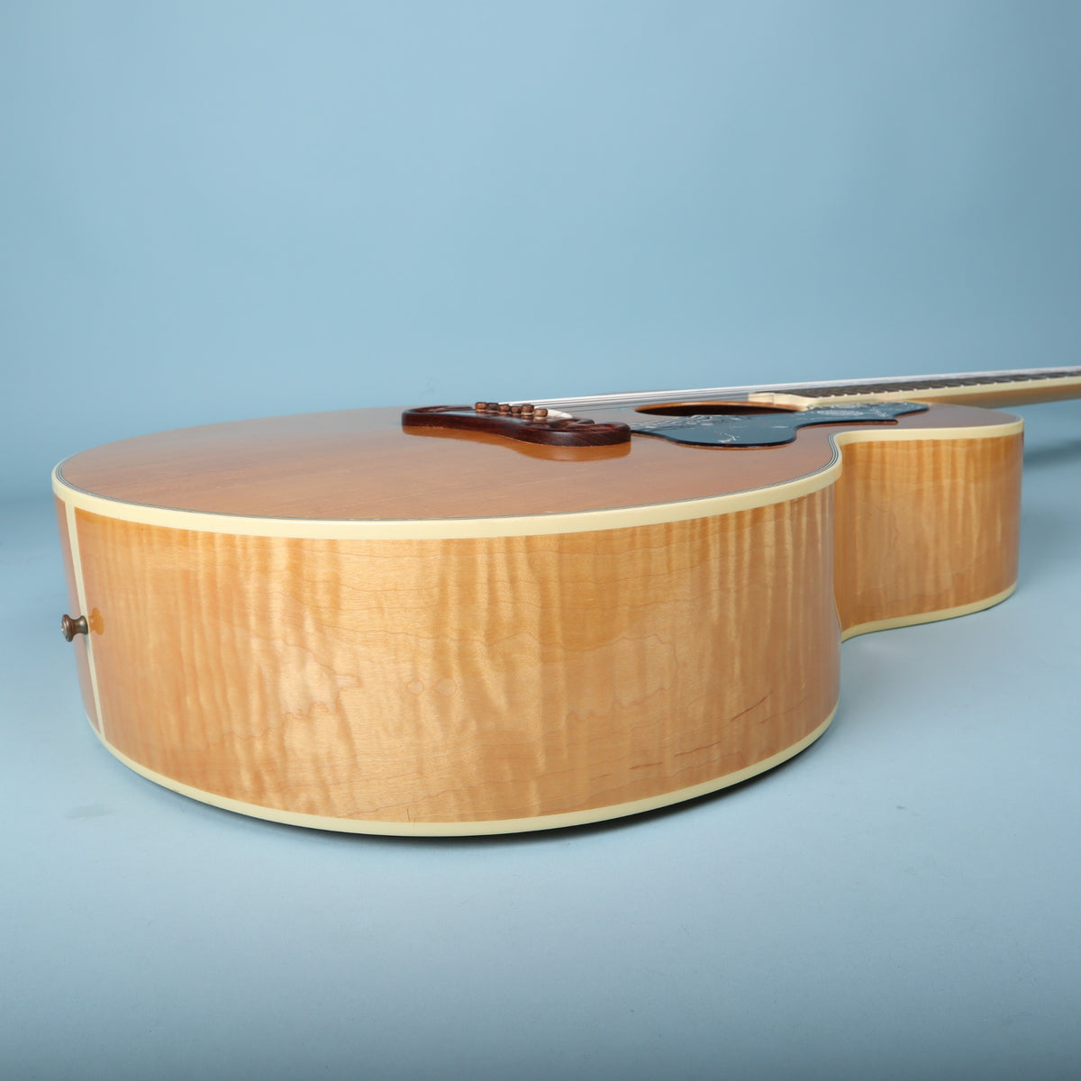 Treble side profile displaying flame maple body rim and cream binding.